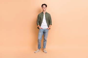 Fototapeta premium Full body length photo of young handsome attractive guy wearing new stylish clothes outfit promo poster advertise isolated on beige color background