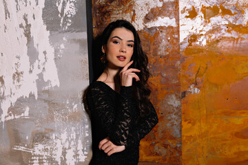 Close up portrait of elegant attractive woman with dark hair wearing black dress posing at camera....