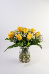 Bouquet of yellow roses in a glass container