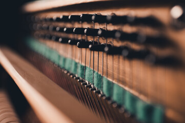 Old vintage acoustic piano inside with hammers and strings close up. Tuning musical instrument....