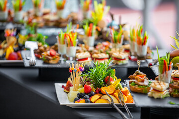 Beautifully decorated catering banquet white table with different food snacks and appetizers