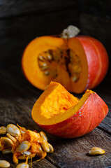 Разрезанная тыква и ее семена на деревянных досках.