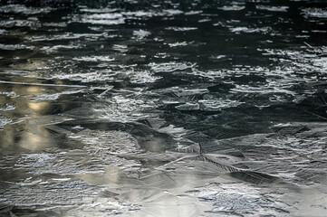One of the Keston Ponds on Keston Common near the village of Keston in Kent, UK. Ice has formed on the surface of the pond making crystalline patterns.