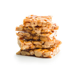 Sweet peanut brittle. Tasty peanuts in caramel isolated on white background.