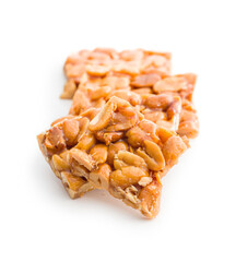 Sweet peanut brittle. Tasty peanuts in caramel isolated on white background.