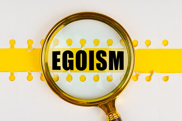 Between two sheets from a notebook on a yellow strip with the inscription - egoism, there is a...