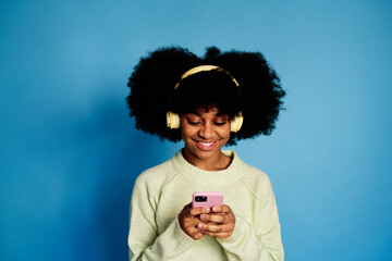 Cheerful black woman using smartphone