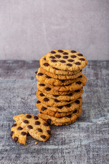 stack of round vanilla cookie with chocolate chips on gray background