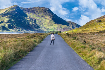 A graceful woman walking the road to the mountains in Connemara, County Galway, Ireland