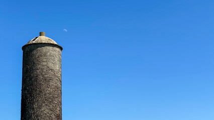 stone silo with blue sky and day moon