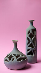 Figuras de cerámica de color verde sobre fondo rosa