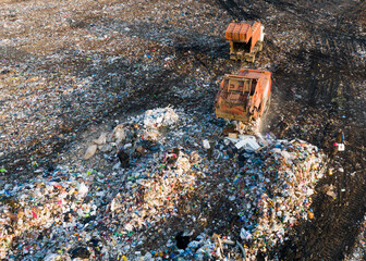 Garbage truck unloads rubbish in landfill. Landfill waste disposal. Garbage dump with waste plastic and polyethylene. Reduce greenhouse gas emissions and methane emissions. Environmental protection.