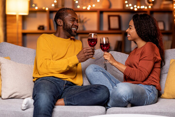 Happy beautiful smiling african american couple drinking red wine