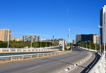Obraz premium City street of the Valencia, Spain. Road traffic, cars on road, people and buildings. Urban building architecture, square, trees in parks and panarama. Car in motion on city streets. Capital center.