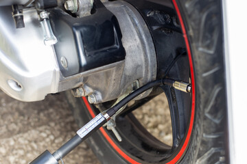 Fototapeta premium a motobike wheel with an air compressor connected to inflate the tire pressure.
