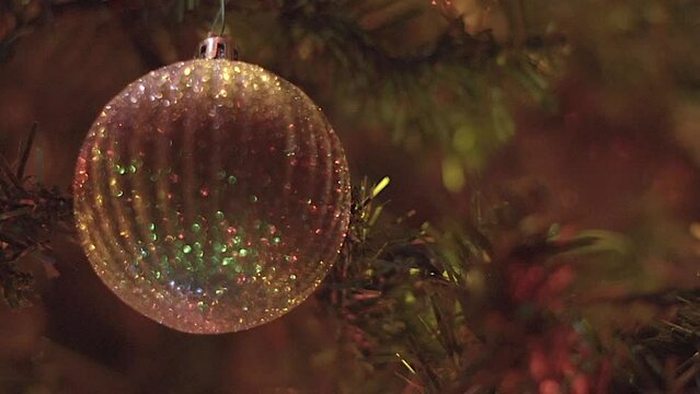 Christmas ornament hanging from tree, closeup in and out of focus bokeh with lights in background