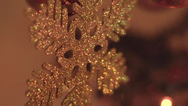 Christmas snowflake ornament hanging from Christmas tree 