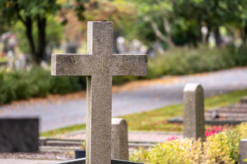 Stone cross on a graveyard in autumn.