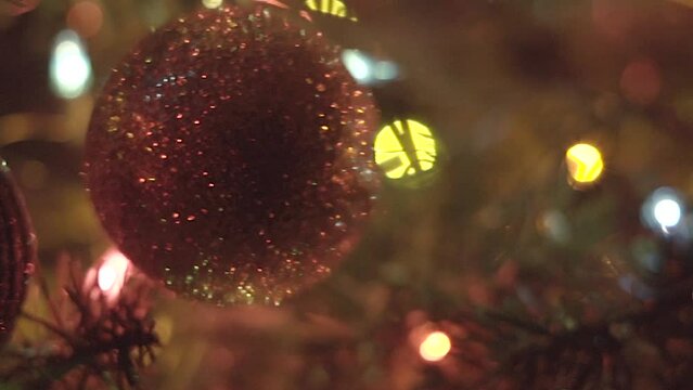 Christmas ornaments sparkling in tree, macro closeup with lights in background