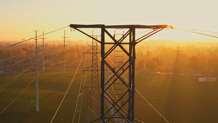 High voltage electric towers at golden hour sunset. Transmission power line and grid...