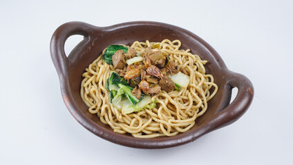 An indonesian chicken noodle with chicken broth in traditional wok