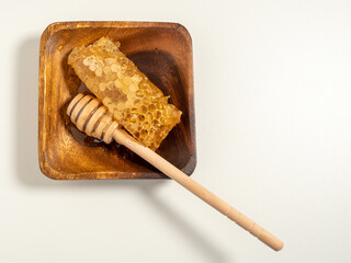 With honeycombs and a wooden spoon for honey in a wooden cup. Honeycombs and honey.