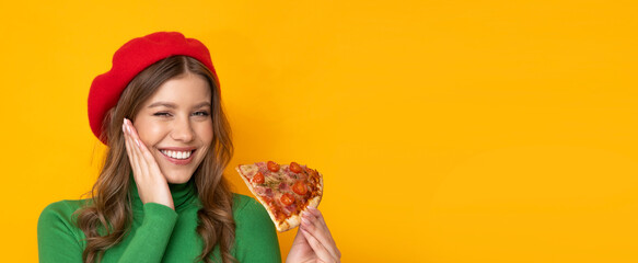 Pretty woman presents most delicious pizza on orange background.