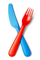 Crossed plastic red fork and blue knife, isolated on white background