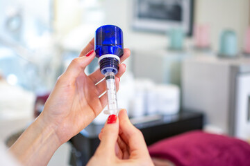 Close up of woman's hands making face injection for cosmetology procedure at beauty salon.