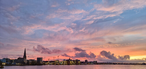sunset over the city of rostock with beautiful colored evening sky