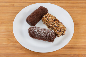 Small soft chocolate cakes with different sprinkling on white dish
