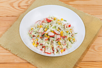 Salad of crab sticks and napa cabbage on rustic table
