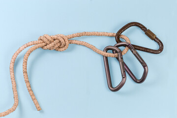 Carabiners in rope knot аigure-eight loop on blue background