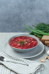 Ukrainian vegetarian borscht with beans on a gray background