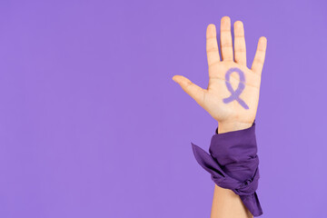 Ribbon drawn on hand of feminist activist isolated on purple background with copy space
