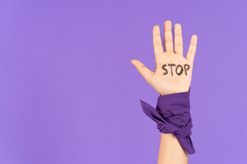 Hand with stop message isolated on purple background with copy space. Feminism, gender violence and...