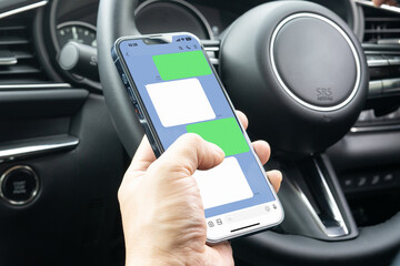 運転席でsnsアプリを使う人物