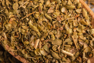 oregano in wooden spoon on gray background