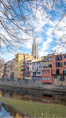 Colorful houses reflected in the Onyar river, in Girona, Catalonia, Spain. Church of Sant Feliu and Cathedral of Santa María in the background