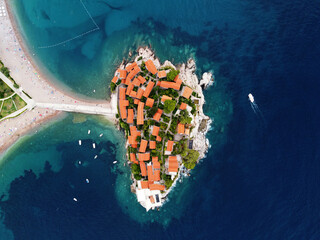 Aerophotography. Aerial view of Sveti Stefan island in a beautiful summer day, Montenegro from flying drone. Panoramic above view of Saint Stephen luxury resort. Tourism and leisure concept.