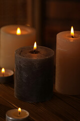 Spa composition with burning candles on wooden table in wellness center, closeup