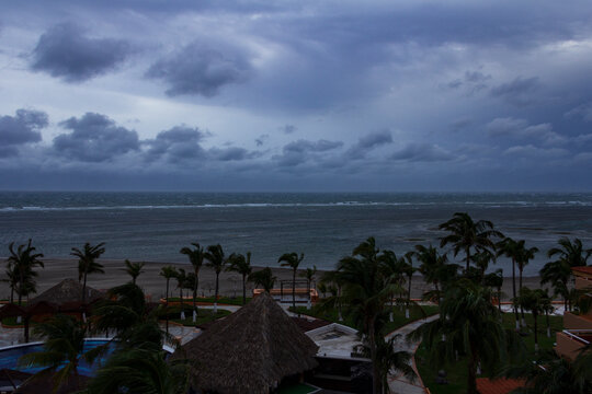 Vista elevada de un resort tropical y el oc&eacute;ano bajo un cielo oscuro y nublado