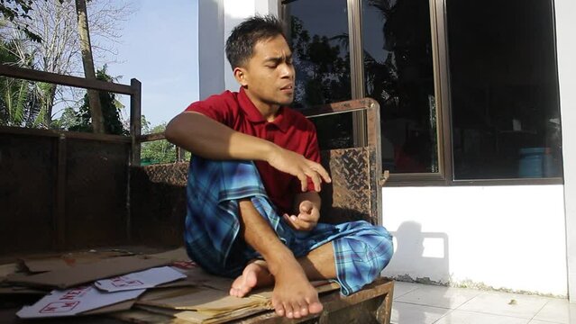 Asian Young Man Sitting While Practicing Voice Vocals For A Theater Performance