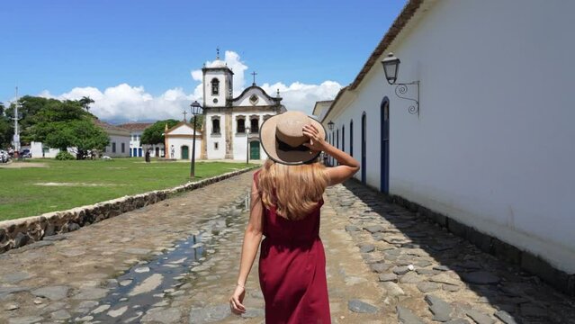 Tourism in Paraty, Brazil. Girl walking in the historic town of Paraty, UNESCO World Heritage Site, Rio de Janeiro, Brazil. Slow motion.