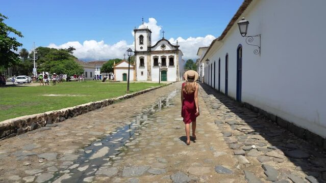 Beautiful young woman walking in the historic town of Paraty, UNESCO World Heritage Site, Rio de Janeiro, Brazil