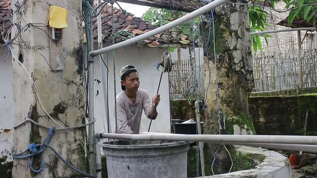 A Young Asian Who Is Drawing Water From A Well
