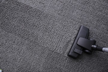 Modern vacuum cleaner on carpet, top view. Space for text