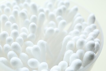 Fototapeta na wymiar Many cotton buds in cup on white background, closeup