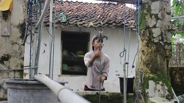 A Young Asian Who Is Drawing Water From A Well