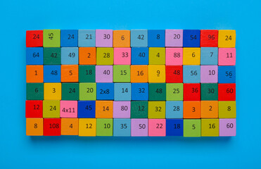 Wooden cubes with different numbers on light blue background, top view